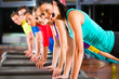Group of people and instructor in gym stretching