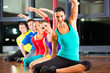 Group of people and instructor in gym stretching