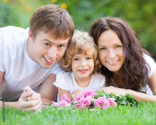 Photo: Happy family lying on green grass Happy family lying on green grass
