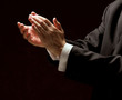 Male hands clapping on black, side-view