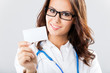 Young female doctor showing blank business card