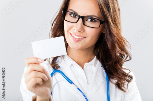 Photo: Young female doctor showing blank business card Young female doctor showing blank business card