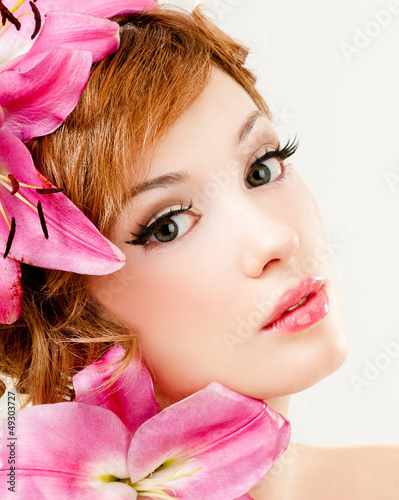 Photo: beautiful girl with pink lilies in her hair beautiful girl with pink lilies in her hair