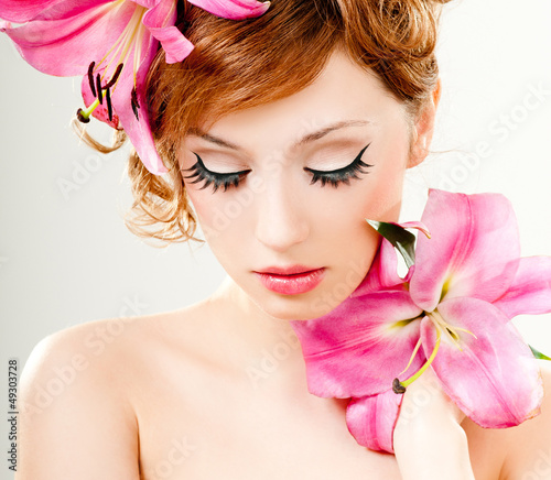 Photo: beautiful girl with pink lilies in her hair beautiful girl with pink lilies in her hair