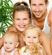 Young happy family with a pet rabbit