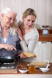 A mature mother and her adult daughter making crepes.