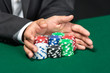 Photo: Poker player going "all in" pushing his chips forward Poker player going "all in" pushing his chips forward
