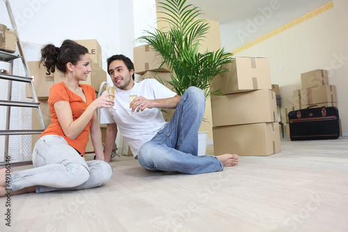 Photo: Couple moving in to flat drinking champagne Couple moving in to flat drinking champagne