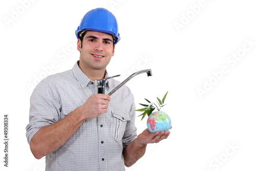 Photo: Plumber holding a faucet over a mini globe Plumber holding a faucet over a mini globe