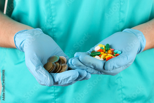 Photo: Doctor gives many different pills, on blue background Doctor gives many different pills, on blue background