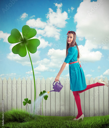 Photo: Woman watering a four leaf clover Woman watering a four leaf clover