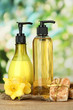 Liquid and hand-made soaps on wooden table, on green background