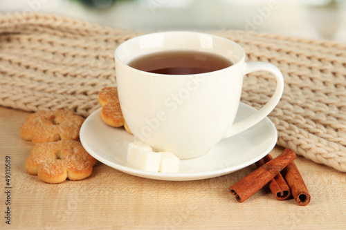 Photo: cup of tea with scarf on table in room cup of tea with scarf on table in room