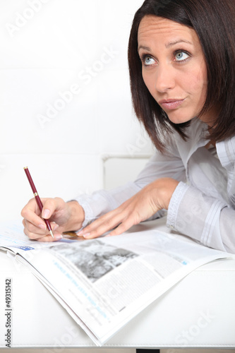 Photo: Woman doing a crossword Woman doing a crossword