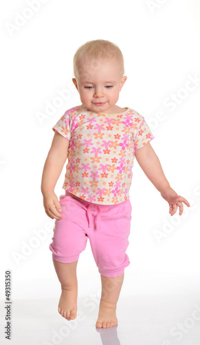 Photo: Funny baby girl running on white background Funny baby girl running on white background