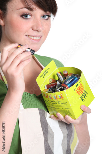 Photo: Woman recycling batteries Woman recycling batteries