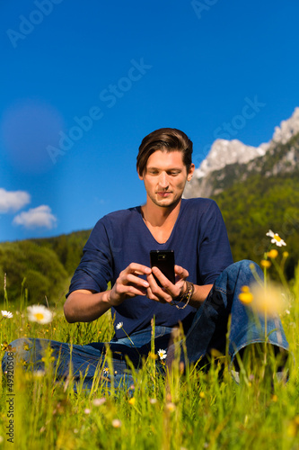 Photo: man with phone sitting in the mountains man with phone sitting in the mountains