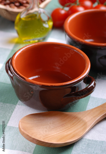 Photo: ciotola di terracotta vuota con cucchiaio di legno ciotola di terracotta vuota con cucchiaio di legno
