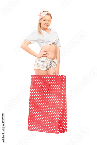 Photo: A young female standing into a red spotted shopping bag A young female standing into a red spotted shopping bag