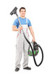 Full length portrait of a young male worker holding a vacuum cle