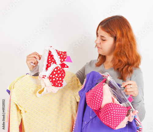 Photo: Beautiful young woman choosing clothes Beautiful young woman choosing clothes