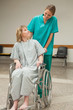 Nurse wheeling a female patient sitting on a wheelchair