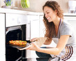 Happy Young Woman Cooking Pizza at Home