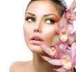 Beautiful Girl With Orchid Flowers. Beauty Model Woman Face