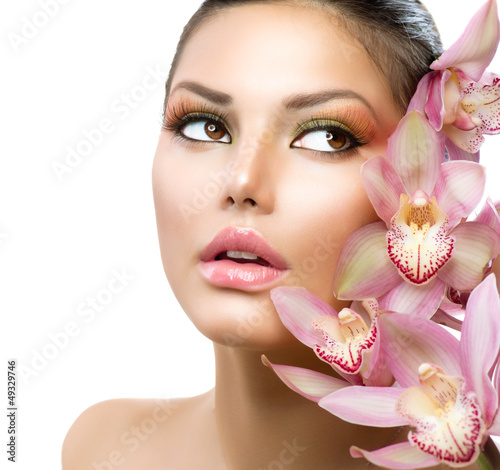 Photo: Beautiful Girl With Orchid Flowers. Beauty Model Woman Face Beautiful Girl With Orchid Flowers. Beauty Model Woman Face