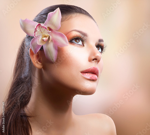 Photo: Beauty Portrait. Beautiful Stylish Girl with Orchid Flower Beauty Portrait. Beautiful Stylish Girl with Orchid Flower