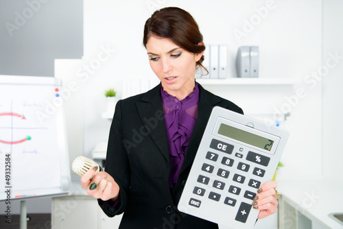 Photo: verärgerte geschäftsfrau mit taschenrechner und thermostat verärgerte geschäftsfrau mit taschenrechner und thermostat
