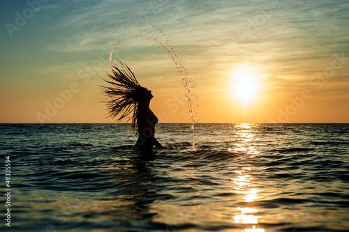 Photo: Silhouettes of woman jumping in ocean Silhouettes of woman jumping in ocean