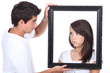 Young couple holding empty picture frame