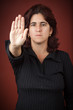 Hispanic woman with her hand extended signaling to stop