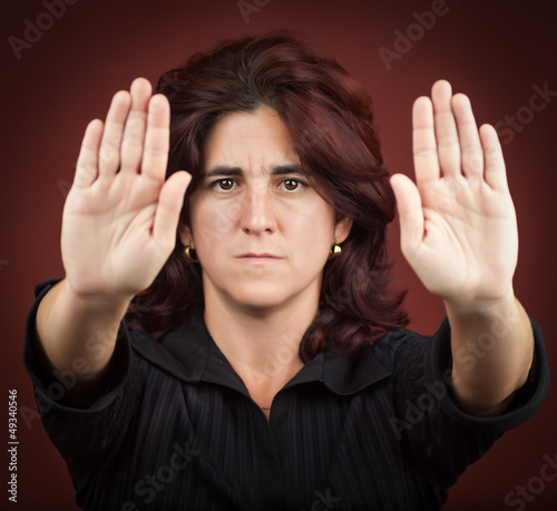 Photo: Hispanic woman with her two hands extended signaling to stop Hispanic woman with her two hands extended signaling to stop