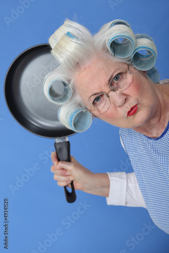 Photo: Angry old lady threatening to use frying pan Angry old lady threatening to use frying pan