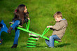 Photo: enfants jouant a la balançoire dans un parc de jeu enfants jouant a la balançoire dans un parc de jeu