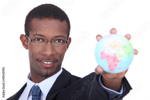 Photo: Businessman holding the world in the palm of his hand Businessman holding the world in the palm of his hand