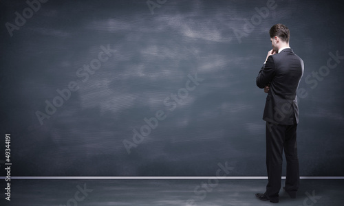 Photo: man looking at blackboard man looking at blackboard
