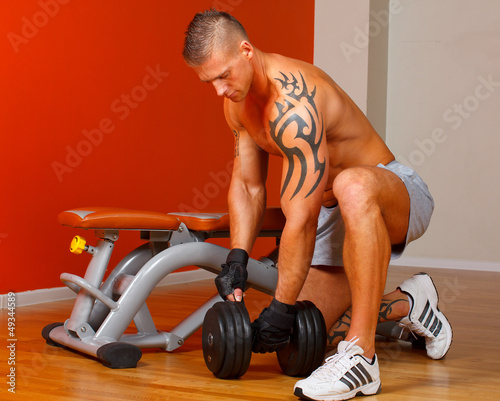 Photo: Handsome man with muscles lift a dumbbell Handsome man with muscles lift a dumbbell