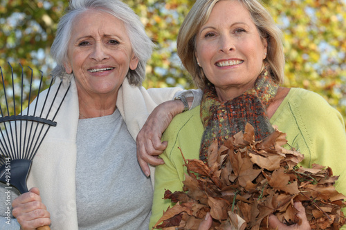 Photo: Two women raking leaves Two women raking leaves