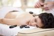 Therapist applying some heat with hot stones during a massage