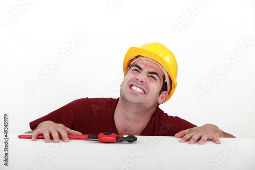 Photo: Grunting tradesman trying to lift himself up onto a ledge Grunting tradesman trying to lift himself up onto a ledge