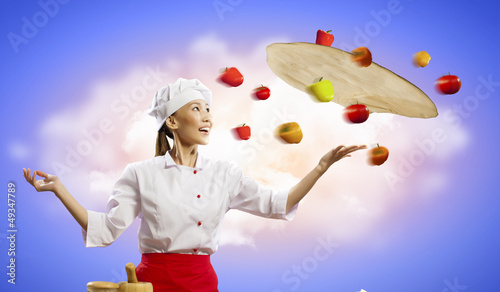 Photo: Asian female cook making pizza Asian female cook making pizza