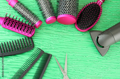 Photo: Comb brushes, hairdryer and cutting shears,on color background Comb brushes, hairdryer and cutting shears,on color background