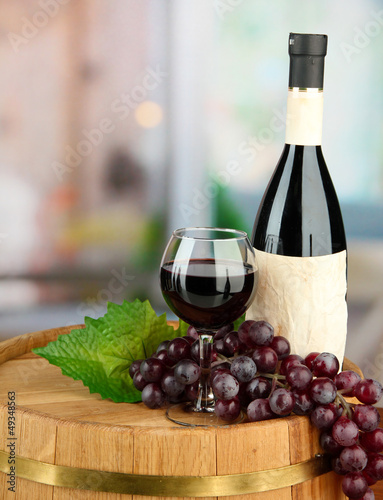Photo: Composition of wine bottle, glass and grape,on wooden barrel, Composition of wine bottle, glass and grape,on wooden barrel,