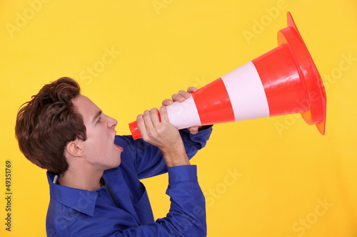 Photo: Man shouting through traffic cone Man shouting through traffic cone