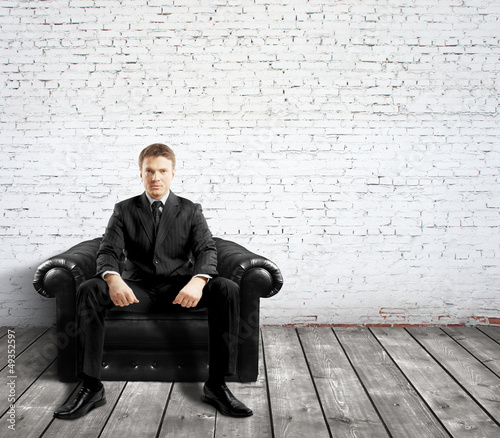 Photo: man sitting on sofa man sitting on sofa