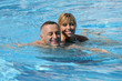 Happy couple swimming together in pool