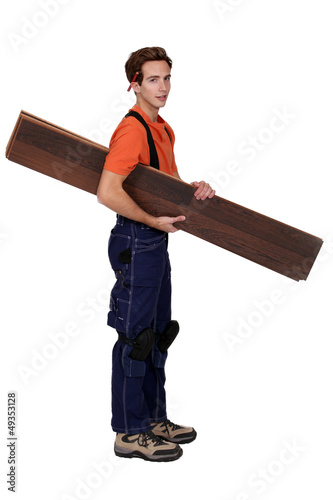 Photo: Handyman holding planks isolated on white background Handyman holding planks isolated on white background